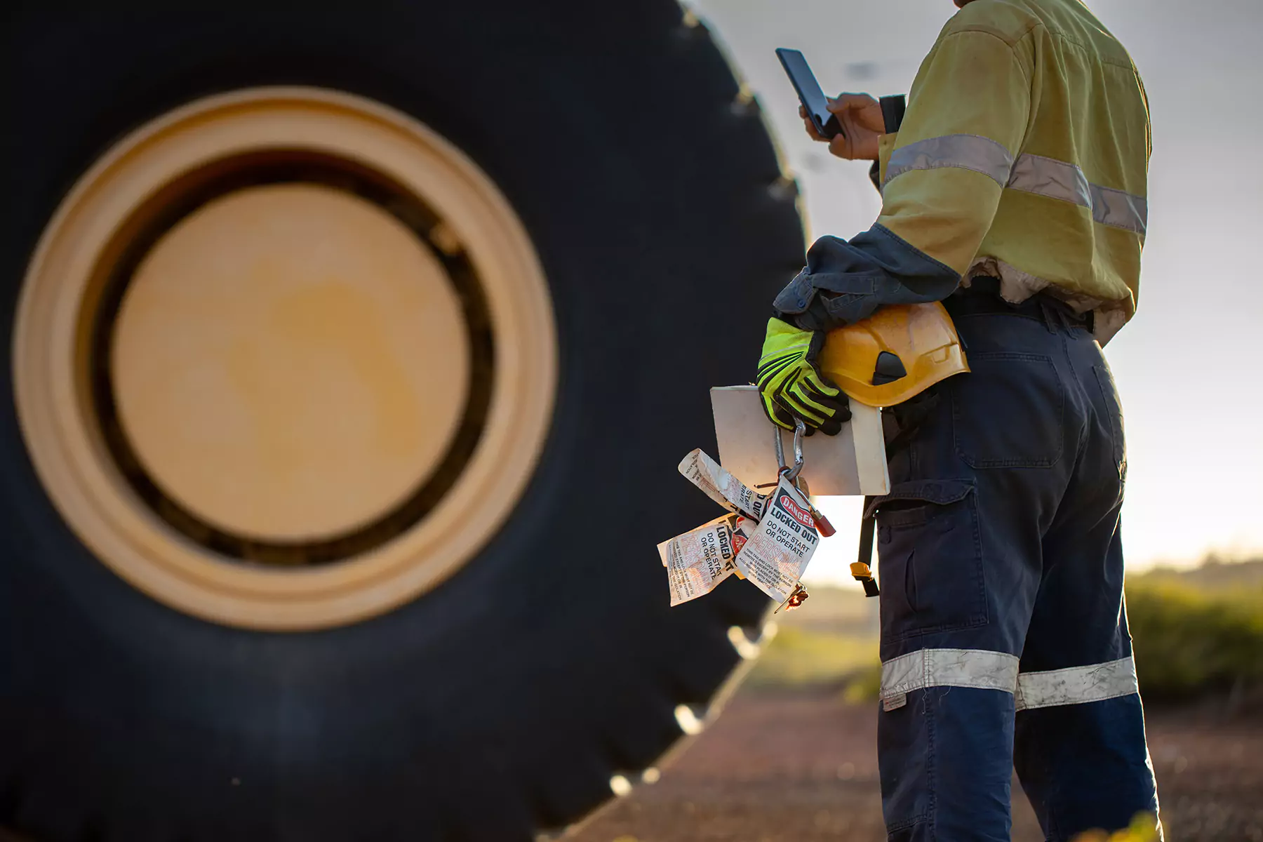 A worker in yellow holding a mobile phone